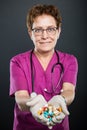 Portrait of senior lady doctor offering bunch of pills Royalty Free Stock Photo