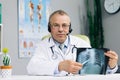 Portrait Senior male doctor wearing headset videoconferencing about corona virus pandemic during group conference video