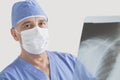 Portrait of senior male surgeon examining x-ray over gray background Royalty Free Stock Photo