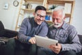 Senior man with adult son using digital tablet at home Royalty Free Stock Photo