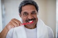 Portrait of senior man brushing teeth in bathroom Royalty Free Stock Photo