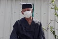 A portrait of a senior man graduate with facial medical mask