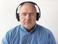 Portrait of senior man in headphones listening to music keeping eyes closed. Relaxing music time. Closeup Royalty Free Stock Photo