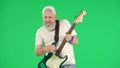 Portrait of senior man hipster on Chroma key green screen background, man in white t-shirt playing on electric guitar at Royalty Free Stock Photo