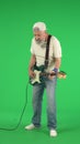 Portrait of senior man hipster on Chroma key green screen, man in white t-shirt playing electric guitar enjoying music Royalty Free Stock Photo