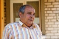 Portrait of a senior man outdoors. 70s years old latin or hispanic man standing outside in summer day. Casual and