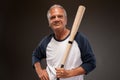 Portrait of a senior man posing with baseball bat