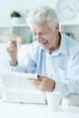 Portrait of senior man reading newspaper at home Royalty Free Stock Photo