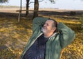 Portrait of a senior man relaxing in wicker chair at warm and sunny autumnal day