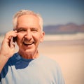 Portrait of senior man talking on mobile phone at beach Royalty Free Stock Photo
