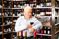 Portrait of senior man tasting red wine at wine shop Royalty Free Stock Photo