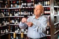 Portrait of senior man tasting red wine at wine shop Royalty Free Stock Photo