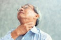Portrait of senior man touching his neck and having throat irritation
