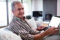 Portrait of senior man using laptop in living room Royalty Free Stock Photo