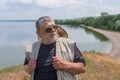 Portrait of senior man wearing dark sunglasses and straw hat standing on Dnipro riverside at summer season Royalty Free Stock Photo