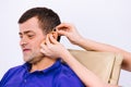 Portrait of a senior man wearing a hearing aid on a white background. New technologies Help for the hard of hearing. Royalty Free Stock Photo