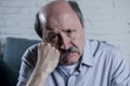 Portrait of senior mature old man on his 60s at home couch alone feeling sad and worried suffering pain and depression Royalty Free Stock Photo