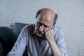 Portrait of senior mature old man on his 60s at home couch alone feeling sad and worried suffering pain and depression Royalty Free Stock Photo