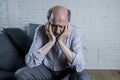 Portrait of senior mature old man on his 60s at home couch alone feeling sad and worried suffering pain and depression Royalty Free Stock Photo