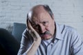 Portrait of senior mature old man on his 60s at home couch alone feeling sad and worried suffering pain and depression Royalty Free Stock Photo