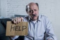 Portrait of senior mature old man on his 60s at home couch alone feeling sad and worried suffering pain and depression Royalty Free Stock Photo