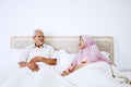 Senior muslim couple talking on bedroom