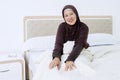 Senior muslim woman sitting on bed