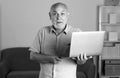 Portrait of senior office worker with a laptop. Senior man with a gray beard has a job in a laptop at home or office Royalty Free Stock Photo