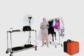 Portrait of senior photographer standing in front of clothes rack in studio Royalty Free Stock Photo