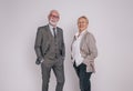 Portrait of senior professional colleagues with hands in pockets smiling against white background Royalty Free Stock Photo