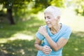 Senior sporty woman has shoulder pain in the park