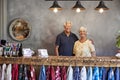 Portrait Of Senior Store Owners Standing Behind Cash Desk Royalty Free Stock Photo