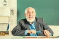 Portrait of senior teacher sitting at desk in classroom. Teacher best friend of learners. School teacher. Study and Royalty Free Stock Photo