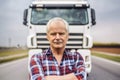 Portrait of senior truck driver in front of a truck. Royalty Free Stock Photo