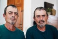 Portrait of senior twin men smiling on camera indoors at home - Focus on faces