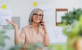 Portrait of senior woman architect with smartphone standing indoors at home, working. Royalty Free Stock Photo