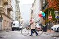 Senior woman with bicycle crossing road outdoors in city.