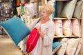 Mature woman choosing pillow at household shop Royalty Free Stock Photo