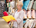 Mature woman choosing pillow at household shop Royalty Free Stock Photo