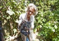 Senior woman cuddling cat while sitting in garden
