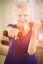 Portrait of senior woman exercising with dumbbells