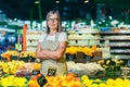 Portrait of senior woman in glasses manager of grocery store, supermarket. Standing in work clothes, arms crossed, looking at the Royalty Free Stock Photo