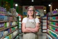 Portrait of senior woman in glasses manager of grocery store, supermarket. Standing in work clothes, arms crossed, looking at the Royalty Free Stock Photo