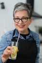 Portrait of a senior woman holding a glass of homemade lemonade