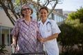 Portrait of senior woman holding walker standing with doctor Royalty Free Stock Photo