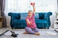 Portrait of senior woman lifting dumbbells extend arms to sides.