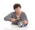 Portrait: senior woman smashing her piggy box. Isolated over white. Royalty Free Stock Photo