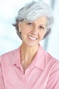 Portrait of senior woman smiling with healthy white teeth. Beautiful old female standing alone inside a room. Happy Royalty Free Stock Photo