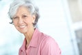 Portrait of senior woman smiling with healthy white teeth. Beautiful old female standing alone inside a room. Happy Royalty Free Stock Photo