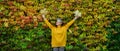 Senior woman standing outdoors against colorful natural autumn background, stretching arms.